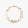 Tria Flow gold bracelet with multiple rows and small blue and white stones, lobster clasp