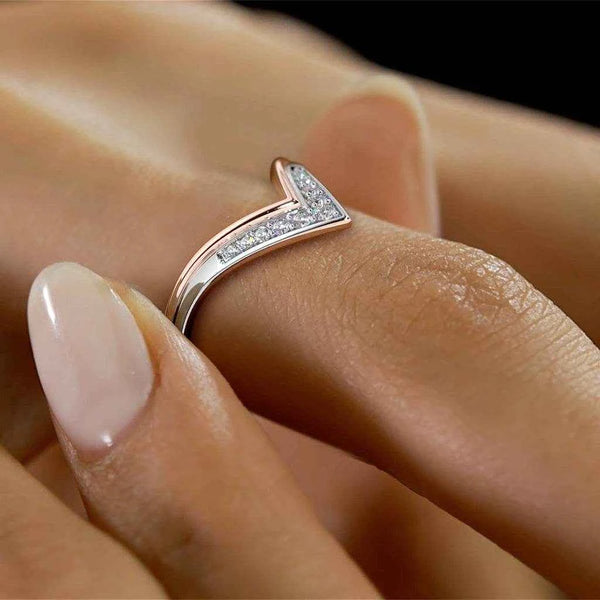 Chevron diamond ring on finger with small V pavé setting in rose-gold and silver.