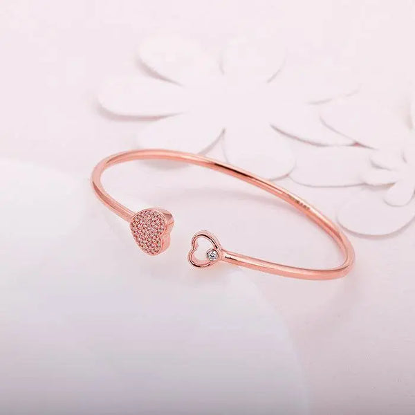Rose gold heart bracelet with two heart charms, one pavé and one with small crystal