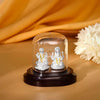 Silver Lakshmi and Ganesha idol under clear glass dome on dark base.