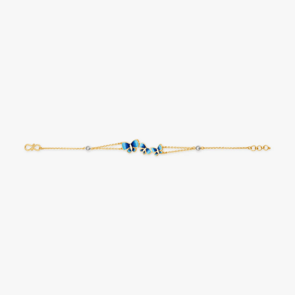 Slim blue butterfly bracelet with gold-tone chain and small blue charm links.