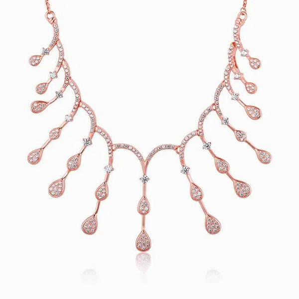 Rose gold fringe necklace with small heart and teardrop charms in an arc