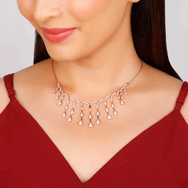Rose gold necklace with short chain and dangling charm drops along the collar