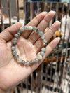 Labradorite bead bracelet with gray-blue round stones held in open palm