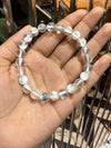Pearly round beaded bracelet with smooth finish, shown in open palm